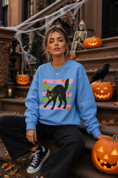 DTF-printed retro hissing black cat with orange stars Halloween crewneck sweatshirt on Sport Grey worn by a model