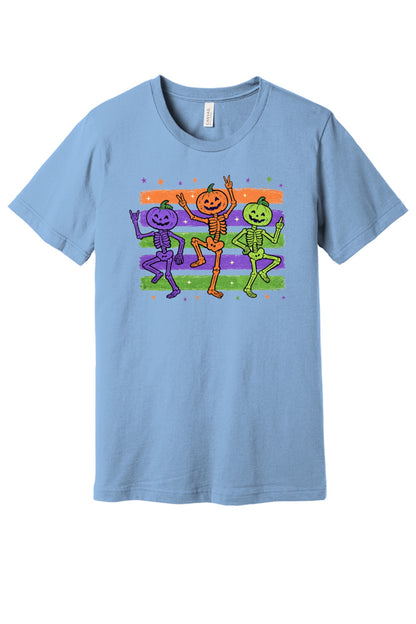 Dancing pumpkin head skeletons Halloween unisex tee in purple orange and green on striped background in Baby Blue