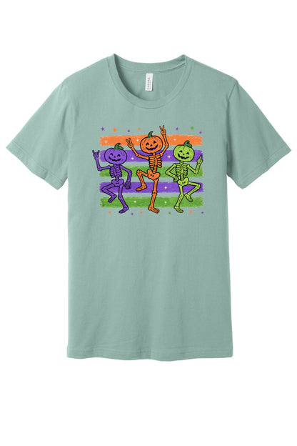 Dancing pumpkin head skeletons Halloween unisex tee in purple orange and green on striped background in Dusty Blue