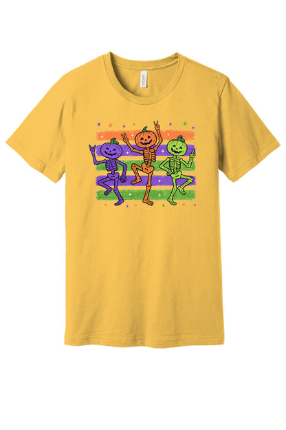 Dancing pumpkin head skeletons Halloween unisex tee in purple orange and green on striped background in Maize Yellow