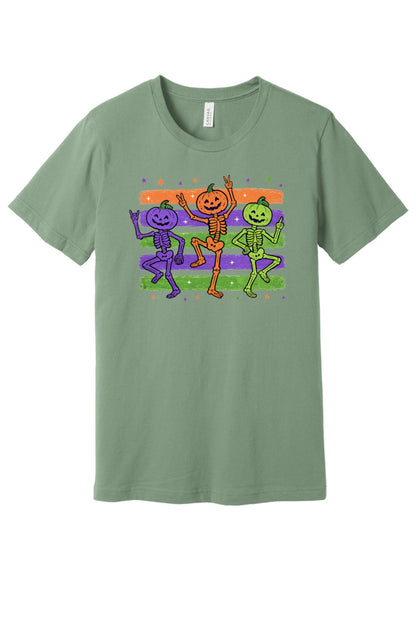 Dancing pumpkin head skeletons Halloween unisex tee in purple orange and green on striped background in Sage