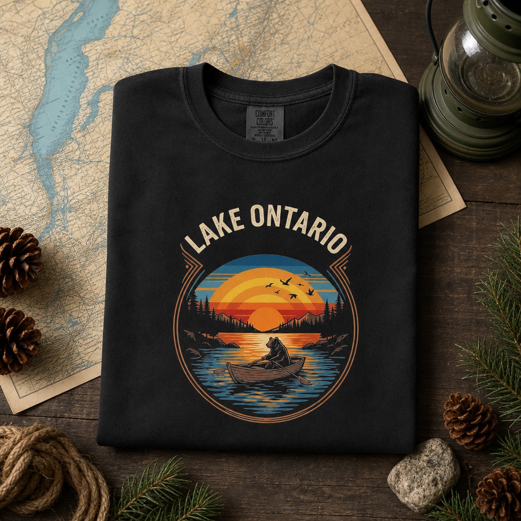 Lake Ontario vintage sunset bear rowing tee, DTF printed on garment-dyed heavyweight cotton shirt, styled flat lay, no model