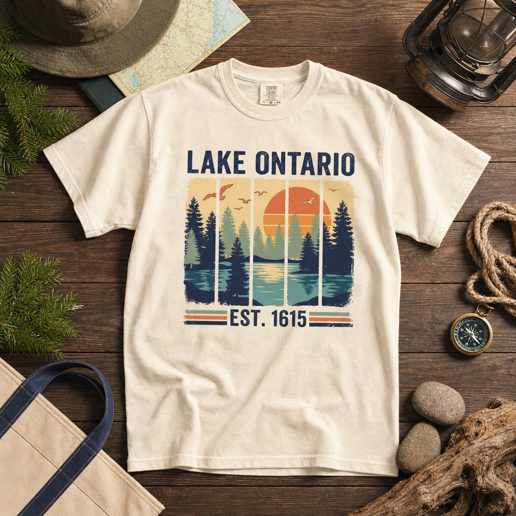 Lake Ontario Est. 1615 vintage pine forest sunset printed on a Comfort Colors heavyweight tee, styled flat lay, no model
