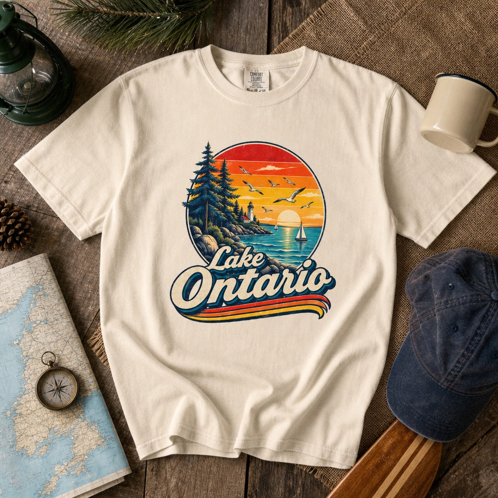 Lake Ontario vintage sunset lighthouse graphic tee with sailboats and seagulls, bold retro script design, styled flat lay, no model