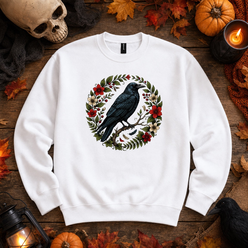 Raven perched on branch inside red floral botanical wreath, printed on a Halloween crewneck sweatshirt, styled flat lay, no model