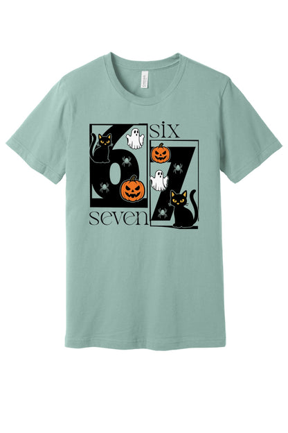 Six Seven Halloween tee with black cats ghosts pumpkins and spiders printed on a unisex short sleeve shirt in Dusty Blue