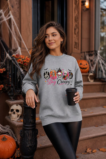 Stay Creepy skeleton Halloween crewneck sweatshirt with flaming skull and heart-eyes DTF print, Gildan 18000 worn by a model