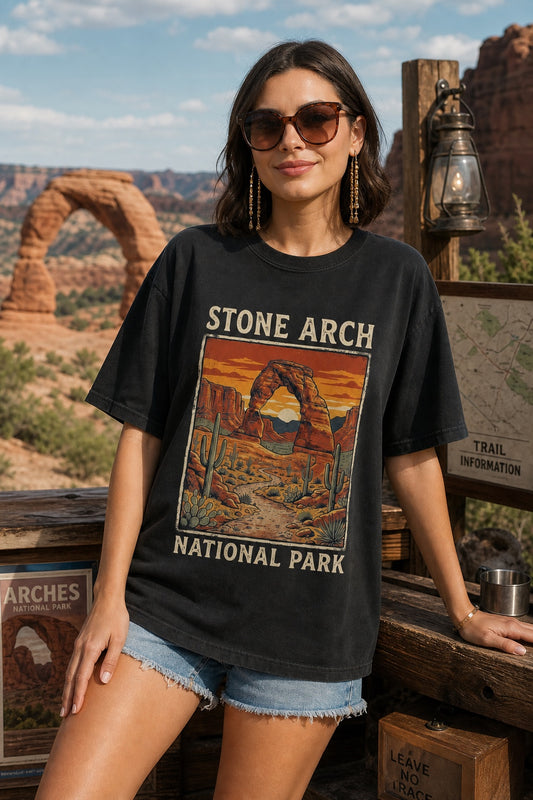 Stone Arch National Park printed tee, retro red rock arch and cactus sunset design on garment-dyed cotton shirt worn by a model