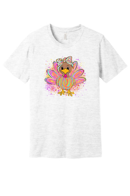 Colorful cartoon girl turkey with bow and tie-dye swirl feathers printed on a unisex Thanksgiving tee in Ash