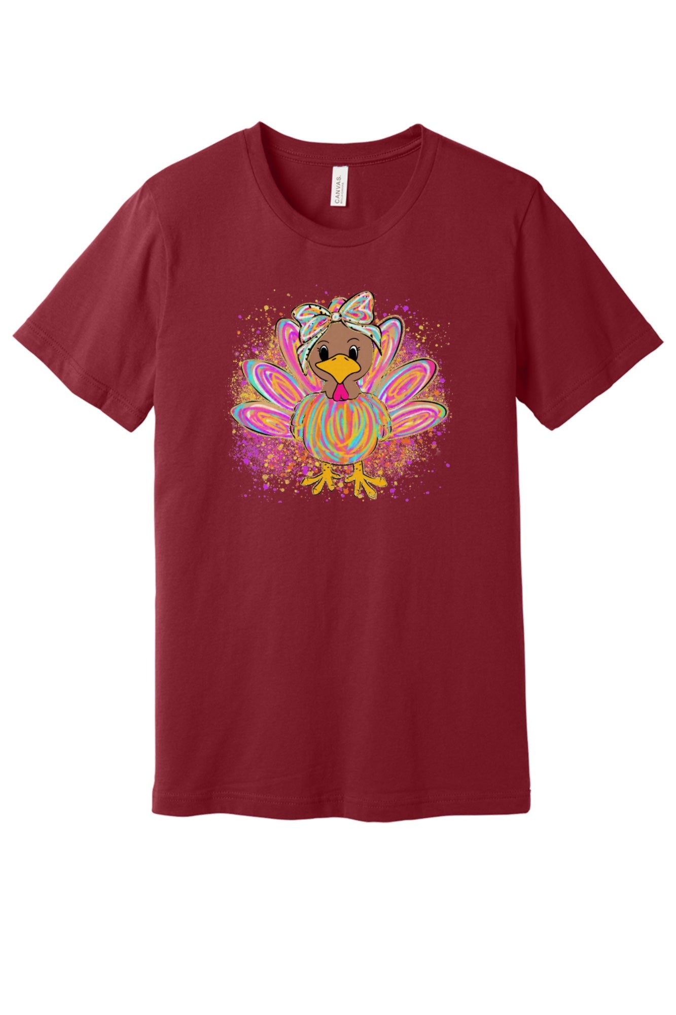 Colorful cartoon girl turkey with bow and tie-dye swirl feathers printed on a unisex Thanksgiving tee in Cardinal