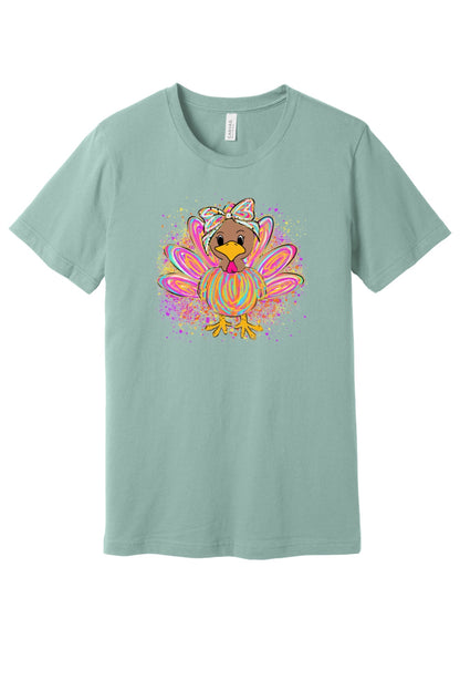 Colorful cartoon girl turkey with bow and tie-dye swirl feathers printed on a unisex Thanksgiving tee in Dusty Blue