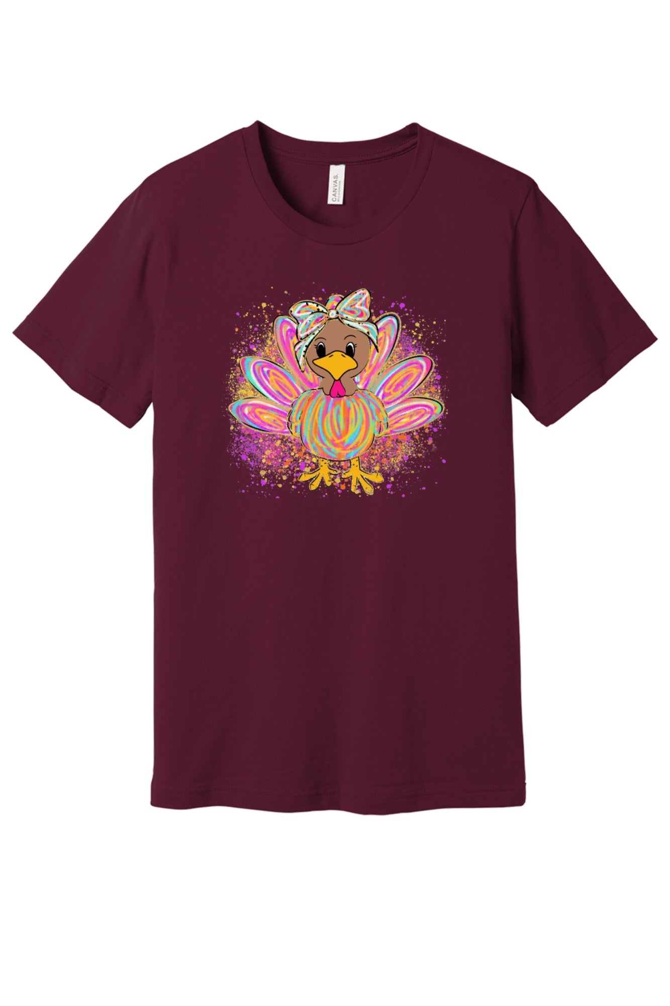 Colorful cartoon girl turkey with bow and tie-dye swirl feathers printed on a unisex Thanksgiving tee in Maroon
