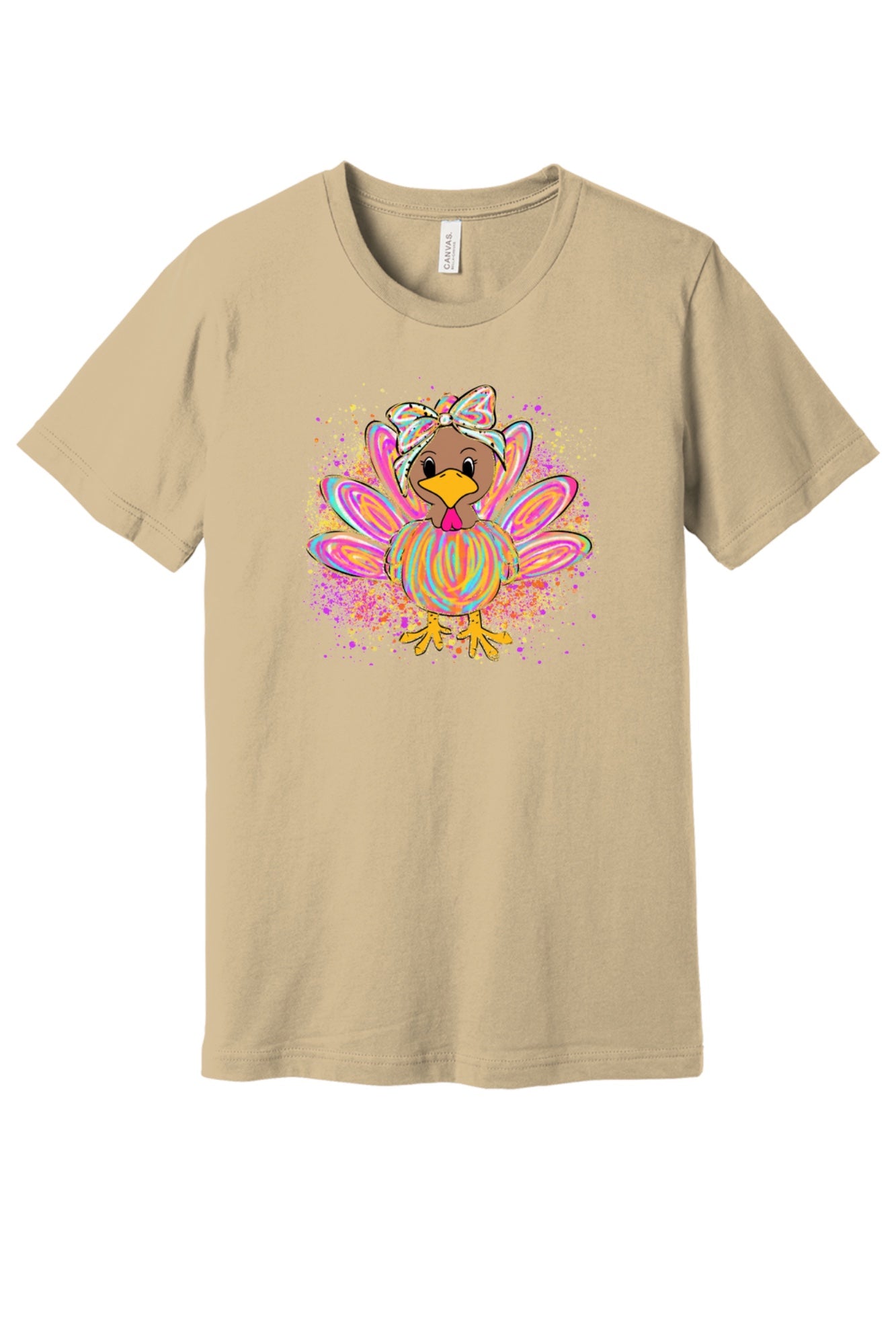 Colorful cartoon girl turkey with bow and tie-dye swirl feathers printed on a unisex Thanksgiving tee in Soft Cream