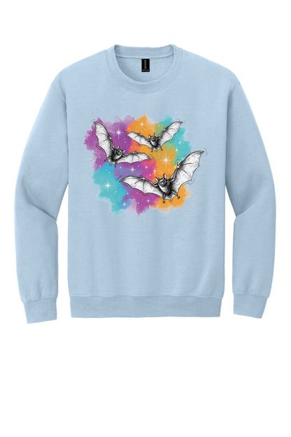 Gildan 18000 crewneck sweatshirt with three sketch-style flying bats over a watercolor purple teal orange sparkle Halloween print in Light Blue